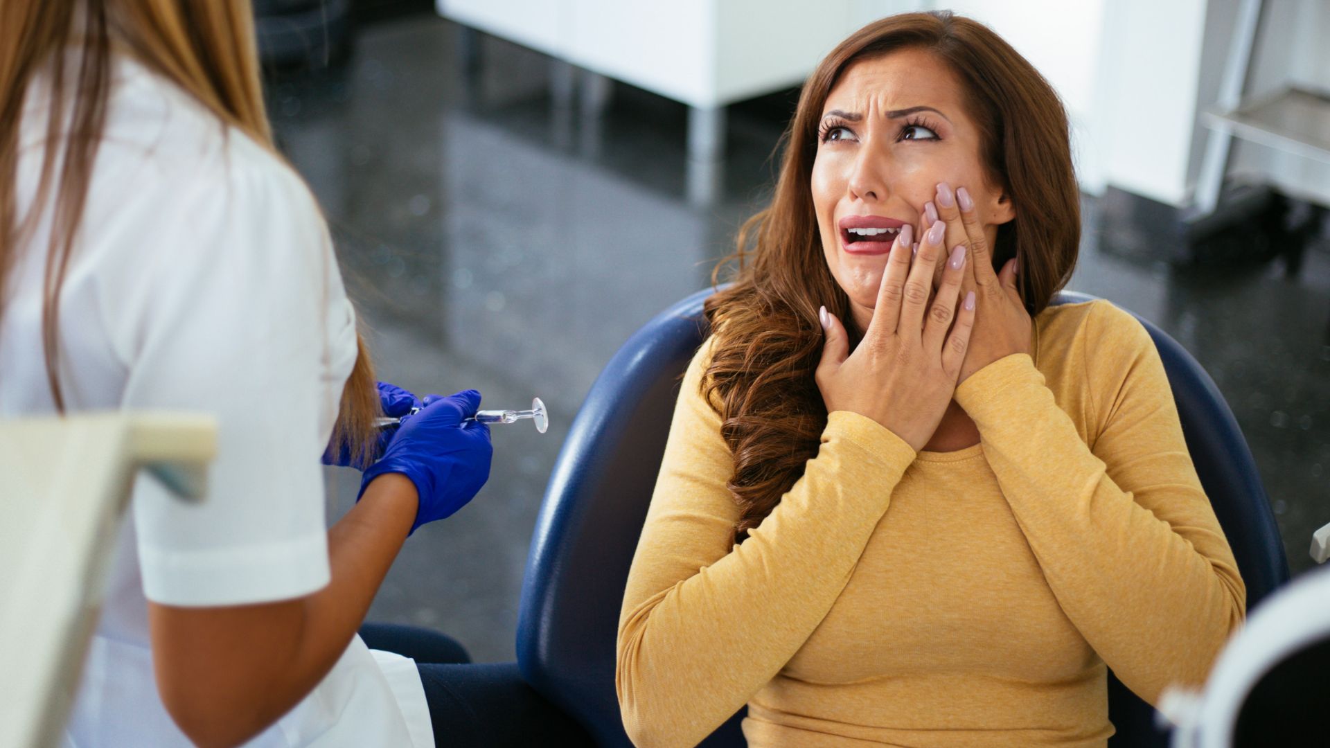 patient-in-pain-root-canal-treatment-in-chandigarh woman in dentist chair for a root canal treatment in chandigarh